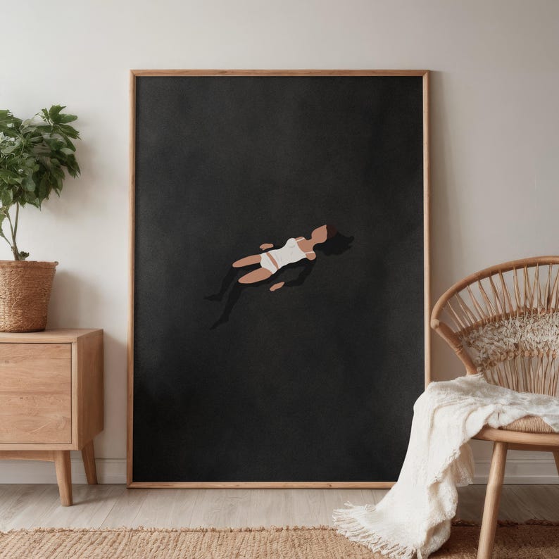 May include: A rectangular framed wall art print featuring a dark charcoal gray background with a stylized illustration of a figure floating in a white swimsuit. The figure has dark hair and tan skin, positioned centrally against the solid dark backdrop.