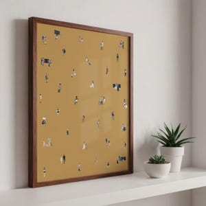 May include: A framed art print featuring a mustard-colored background with numerous tiny figures. The figures are depicted in various poses, suggesting a crowd or gathering. The frame is a dark brown wood, and the artwork is displayed on a white shelf with potted plants.