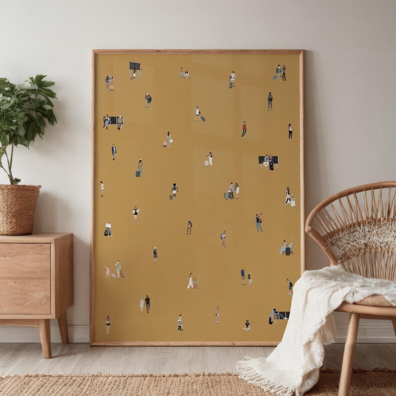 May include: A framed art print featuring a mustard-yellow background with numerous tiny figures scattered across it. The figures are depicted in various poses, some with luggage, suggesting a travel or airport theme. The frame is a light brown color.