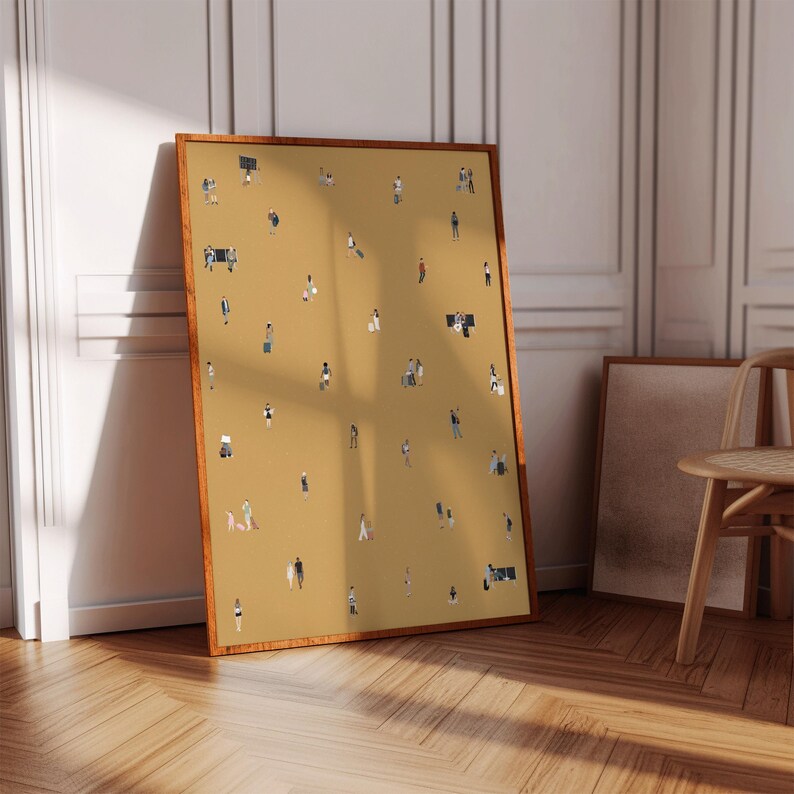 May include: A framed art print featuring a mustard-colored background with numerous tiny figures. The figures are depicted in various poses, suggesting a crowd or gathering. The frame is a warm brown color, and the artwork is leaning against a wall.