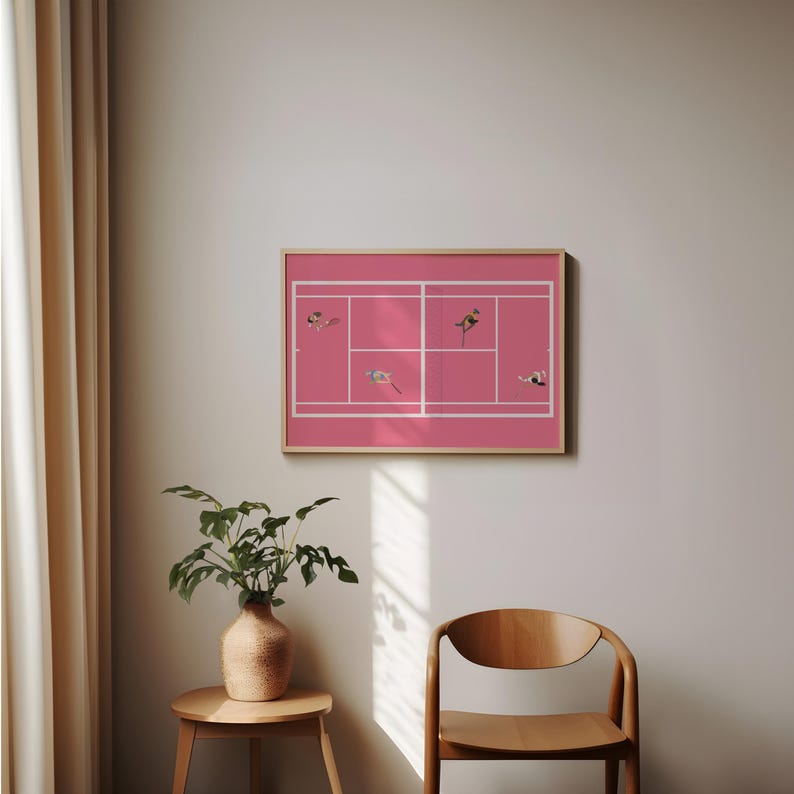 May include: A framed print of a pink tennis court with white lines and small figures of people playing tennis.