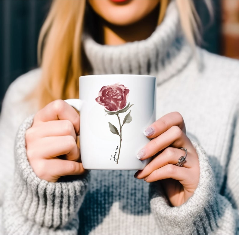 May include: White ceramic mug with a watercolor illustration of a single pink rose and the name "Jessica" written in cursive.