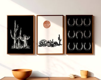 May include: Three framed black and white illustrations. The first illustration shows a desert landscape with cacti and a large red sun. The second illustration shows two cacti in a black background. The third illustration shows a pattern of nine white horseshoes on a black background.