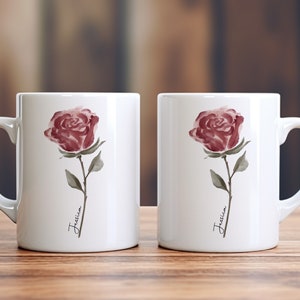 May include: Two white ceramic mugs with a watercolor rose design and the name "Jessica" written on each mug.
