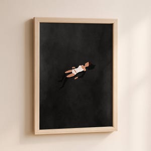 May include: A framed wall art print featuring a minimalist illustration of a figure floating in a vast, solid black space. The figure is depicted with dark hair, wearing a white tank top and white shorts, positioned centrally against the dark background.