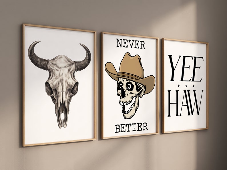 May include: Three framed prints with a western theme. The left print features a black and white drawing of a bull skull. The middle print features a skull wearing a cowboy hat with the text "NEVER BETTER". The right print features the text "YEE HAW" in black.