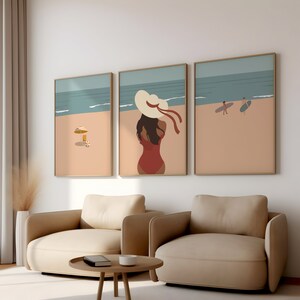 May include: Three framed illustrations of a beach scene. The center illustration features a woman in a red swimsuit and a large white sun hat. The left illustration shows a beach umbrella and a beach chair. The right illustration shows two people walking on the beach with surfboards.