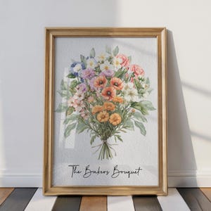 Op de afbeelding: Een ingelijste print met een aquarelboeket van kleurrijke bloemen, waaronder oranje klaprozen, roze rozen en paarse bloemen. Het boeket is vastgebonden met touw en de tekst "The Bakers Bouquet" staat eronder in cursief. De lijst is goudkleurig.