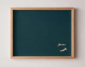 Könnte beinhalten: Ein gerahmter Wandkunstdruck mit einem einfarbigen, dunkel-türkisblauen Hintergrund und zwei kleinen Figuren, die in der unteren rechten Ecke schwimmen. Eine Figur hat dunkles Haar und schwarze Badekleidung, die andere blondes Haar und helle Badekleidung.