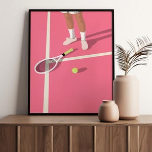 May include: A pink tennis court with a white tennis racket lying on the ground and a yellow tennis ball. A person's legs and feet are visible in the top of the image.