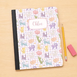 May include: A notebook with a black spine and a light purple gingham cover featuring a repeating pattern of colorful cats and small stars. A central white rectangular label displays the name Chloe in script. A yellow pencil and pink eraser.