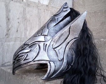 May include: A silver helmet with a black feathered plume. The helmet is decorated with intricate carvings and has a sharp, angular design.