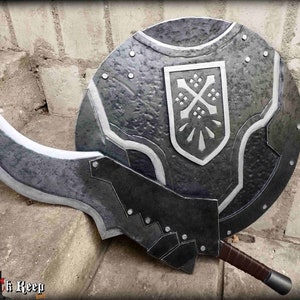 Puede incluir: Un escudo negro y plateado con un diseño estilizado y una espada a juego con una hoja curva.