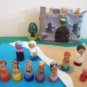 May include: A set of wooden peg dolls, including a castle, a tree, and a variety of characters. The dolls are painted in bright colors and have detailed features. The set is perfect for imaginative play and storytelling.