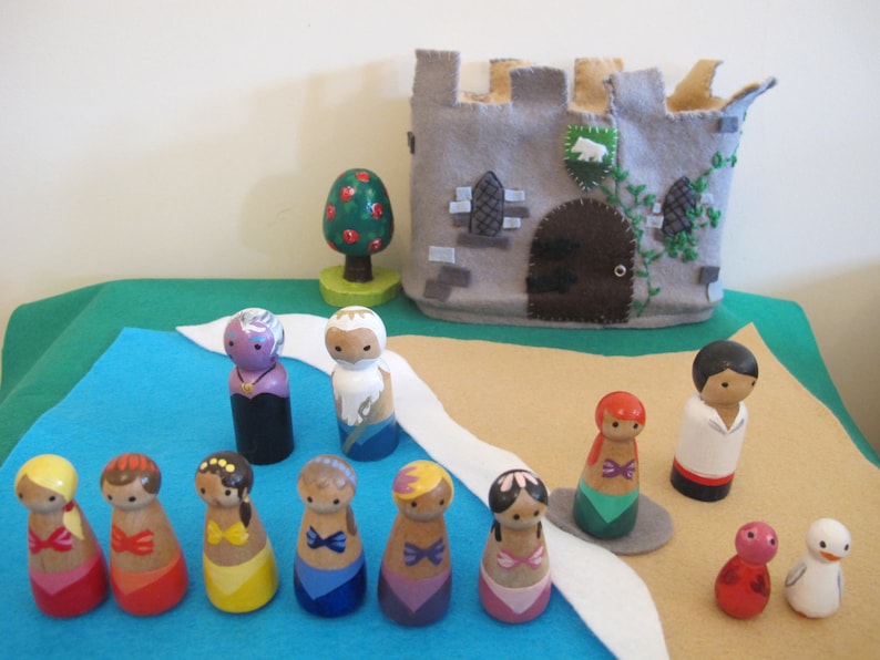 May include: A set of wooden peg dolls, including a castle, a tree, and a variety of characters. The dolls are painted in bright colors and have detailed features. The set is perfect for imaginative play and storytelling.
