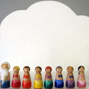May include: A set of 14 wooden peg dolls, painted in various colors, depicting characters from the Little Mermaid. The dolls are arranged in a row, with a white cloud-shaped background.