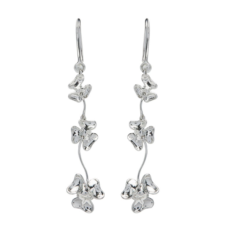 May include: Silver dangle earrings with three clover-shaped charms on each earring.