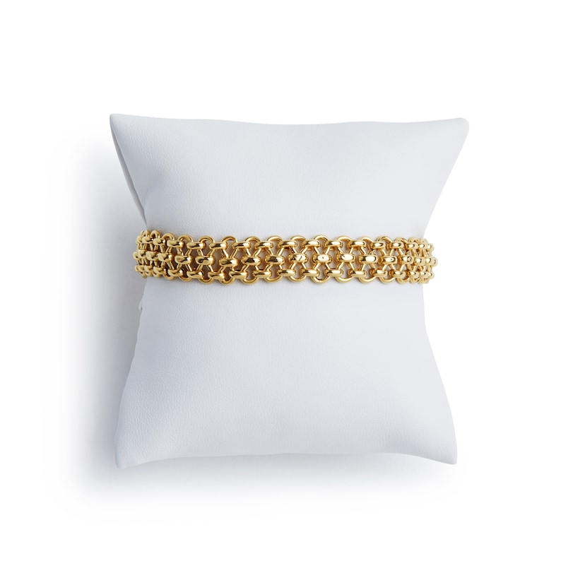 May include: A gold chain bracelet on a white pillow. The bracelet is made of interlocking links.