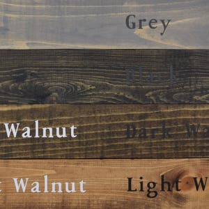 May include: Four wood samples stained in different colors: grey, black, dark walnut, and light walnut.
