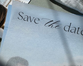 May include: A light blue card with the text "Save the date" written in black calligraphy.