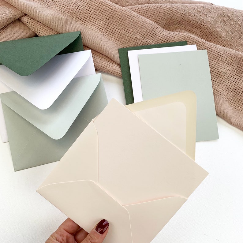 Powder pink blank card and envelope set held in hand. A2 size - 4 1/4 x 5 1/2 inches.