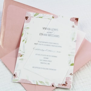 May include: A wedding invitation with a floral design in shades of pink and green. The invitation is printed on a clear sheet of paper and is placed inside a pink envelope. The text on the invitation reads: "Vivian Lewis and Ethan Williams, Together with their families invite you to celebrate their wedding, Saturday, October 17, 2020, at five o'clock in the evening, Avenir, 1601 Main Street, Walpole, MA, Reception to follow ceremony."