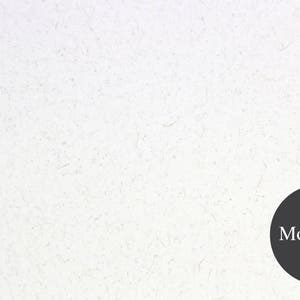 May include: A white textured background with a black circle in the bottom right corner. The circle contains the text "Moonrock" in white.