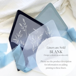 May include: An open navy blue envelope with a light blue liner featuring a white floral design. A translucent overlay with the same design is visible. Light blue ribbon and text that reads "Liners are Sold BLANK" are also visible.