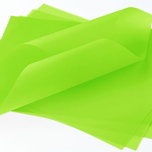 May include: A stack of bright green tissue paper sheets. The paper is translucent and has a slightly crinkled texture.