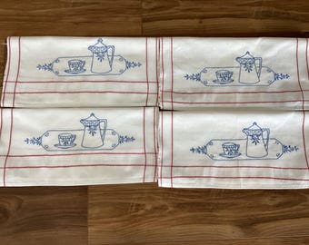 May include: Four white tea towels with red and blue embroidery. Each towel features a design of a teapot and a teacup on a tray with floral accents.