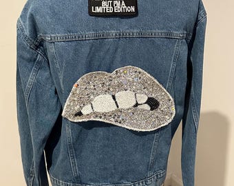 May include: A blue denim jacket with a silver sequined lips patch and a black patch that says "I'm not perfect but I'm a limited edition."