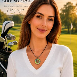 May include: A woman wearing a black cord necklace with a round pendant. The pendant has a colorful, glittery design. The text "GLITTER GOLF NECKLACE" is at the top of the image, with the text "Wear your game" below.