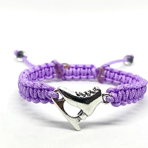 May include: A purple braided bracelet with a silver ice skate charm.