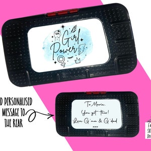 May include: Black rectangular case with a white insert featuring the words "Girl Power" in script and various symbols. The case has a red clasp. The bottom case has a personalized message.