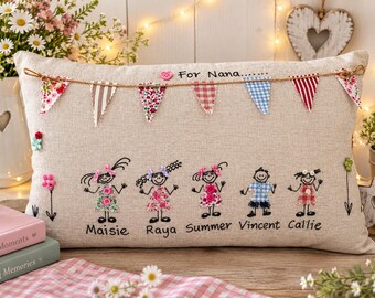 Peut inclure: Un coussin rectangulaire beige orné de silhouettes brodées de cinq enfants nommés Maisie, Raya, Summer, Vincent et Callie. Le coussin est décoré d'une guirlande de fanions en tissu, d'un bouton rose et du texte For Nana.