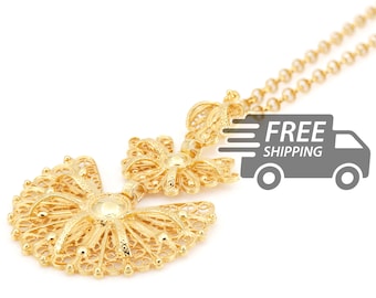 May include: A gold-toned necklace featuring a delicate filigree pendant with a fan-shaped base and a smaller floral-like top section. The metalwork consists of intricate, airy wire patterns and small spherical accents, suspended from a matching chain.
