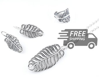 May include: A silver jewellery set featuring a necklace with a large feather pendant, two matching feather earrings with hook backings, and an adjustable feather ring. Each piece displays a detailed, openwork filigree design with oxidised accents.