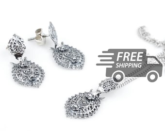 May include: A pair of silver filigree earrings and a matching silver filigree pendant on a chain. Each piece features an intricate, openwork heart-shaped design with a textured, oxidized finish and a small central circular motif.