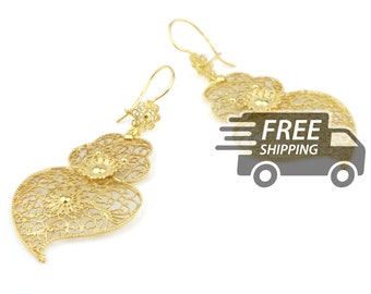 May include: A pair of gold-tone drop earrings featuring intricate filigree metalwork in a heart-like shape. Each earring consists of a delicate openwork pattern with a small circular stud at the top and a larger, teardrop-shaped pendant below.
