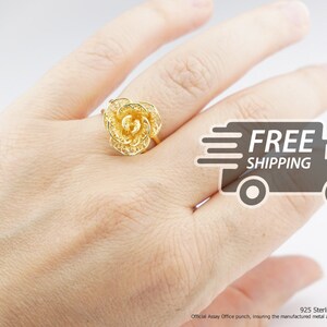 Peut inclure: Une bague en forme de rose dorée en argent sterling 925. La bague est sur une main, et l'image comprend le texte "LIVRAISON GRATUITE" et "Argent Sterling 925".