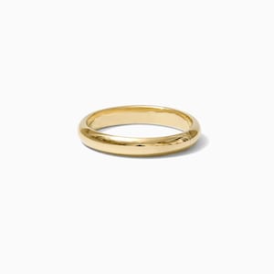 May include: A simple gold band ring with a smooth, polished finish.