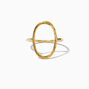 May include: A gold hammered oval ring with a large open circle in the center.