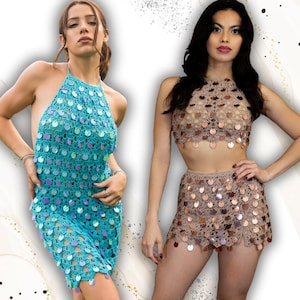 May include: Two crochet outfits. One is a turquoise halter dress with iridescent sequins. The other is a tan crochet crop top and matching mini skirt, also adorned with sequins. Both outfits are handmade and suitable for a beach or festival.