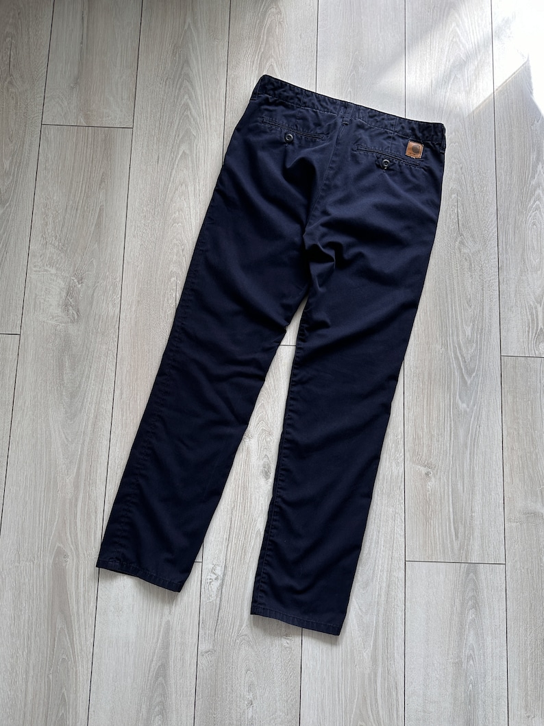 K&ouml;nnte beinhalten: Marineblaue Hose mit klassischem Design. Die Hose hat einen Knopfverschluss, zwei Ges&auml;&szlig;taschen und ein kleines Logo-Patch. Hergestellt aus strapazierf&auml;higem Stoff, ist diese Hose f&uuml;r den t&auml;glichen Gebrauch geeignet.