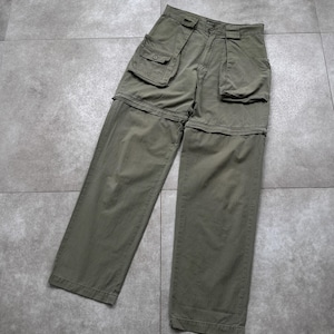 May include: Olive green convertible cargo pants with multiple pockets. The pants feature a zip-off design, allowing them to be converted into shorts. The pants are made of a durable fabric and have a classic, utilitarian style.