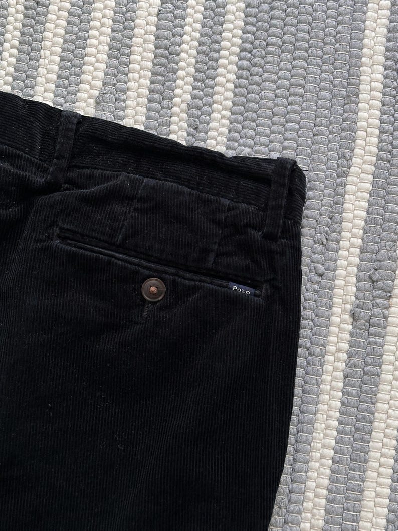 Puede incluir: Pantal&oacute;n de pana negro con un bolsillo trasero y una peque&ntilde;a etiqueta Polo.