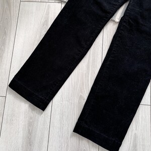 Puede incluir: Un pantal&oacute;n de pana negro de pierna recta.