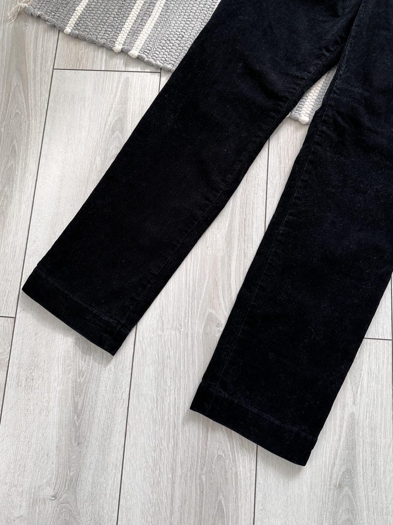 Puede incluir: Un pantal&oacute;n de pana negro de pierna recta.
