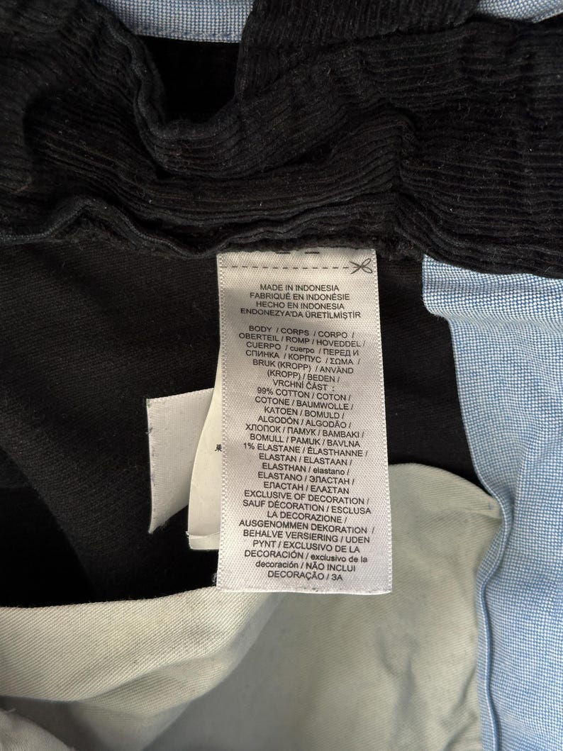 Puede incluir: Una etiqueta blanca con texto negro que detalla la composici&oacute;n de la tela y el origen de la prenda. La etiqueta dice "Made in Indonesia, Fabriqu&eacute; en Indon&eacute;sie, Hecho en Indonesia, Endonezya'da &Uuml;retilmiştir. Body/Corps/Corpo Oberteil/Romp/Hovedel/Cuerpo/Cuerpo/Перед и Спинка/&Kappa;&omicron;&rho;&pi;&upsilon;&sigmaf; &Sigma;&omega;&mu;&alpha;  Bruk (Kropp)/Anv&auml;nd (Kropp)/Beden/Vrchn&iacute; Č&aacute;st: 99% Cotton/Coton/Coton/Baumwolle/Katoen/Bomuld/Algod&oacute;n/Algod&atilde;o/Хлопок/Памук/Вамвакі Bomull/Pamuk/Bavlna 1% Elastane/Elasthanne/Elastan/Elastaan/Elasthan/elastano/Elastano/ЭЛАСТАН/ЕЛАСТАН/&Epsilon;&Lambda;&Alpha;&Sigma;&Tau;&Alpha;&Nu; Exclusive of Decoration/Sauf Decoration/Esclusa la Decorazione/Ausgenommen Dekoration/Behalve Versiering/Uden Pynt/Exclusivo de la Decoraci&oacute;n/exclusivo de la decoraci&oacute;n/N&Atilde;O INCLUI DECORA&Ccedil;&Atilde;O/3A"
