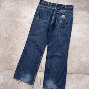 Puede incluir: Vaqueros de mezclilla azul oscuro con un lavado descolorido y dobladillos deshilachados. Los vaqueros presentan un dise&ntilde;o cl&aacute;sico de cinco bolsillos y un peque&ntilde;o parche con el logotipo en el bolsillo trasero. Corte relajado.